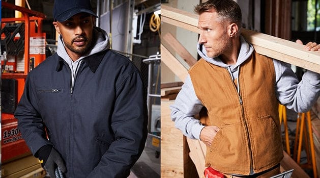 Two men wearing jackets in a workshop setting.